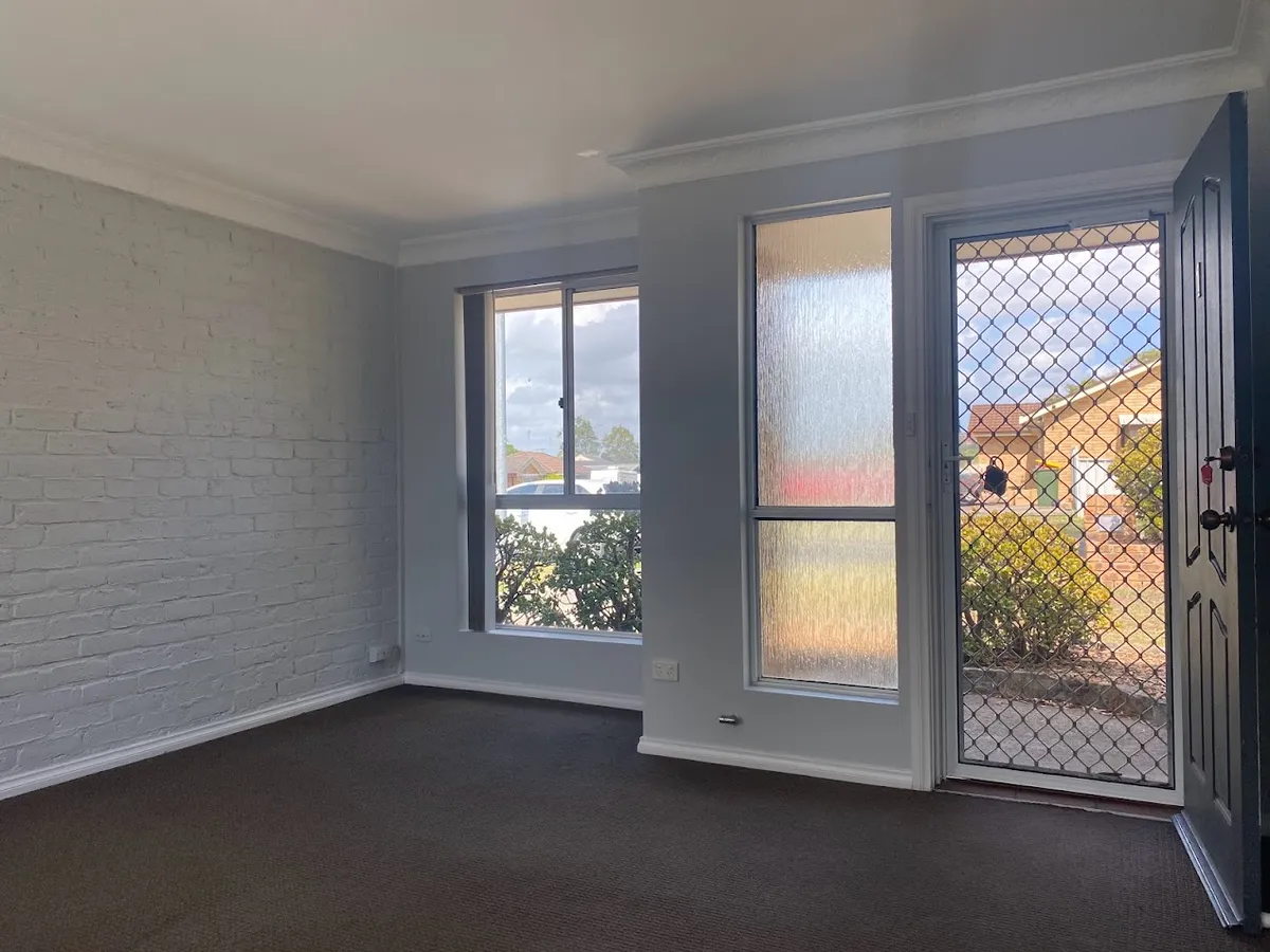 Carpeted lounge room with front door