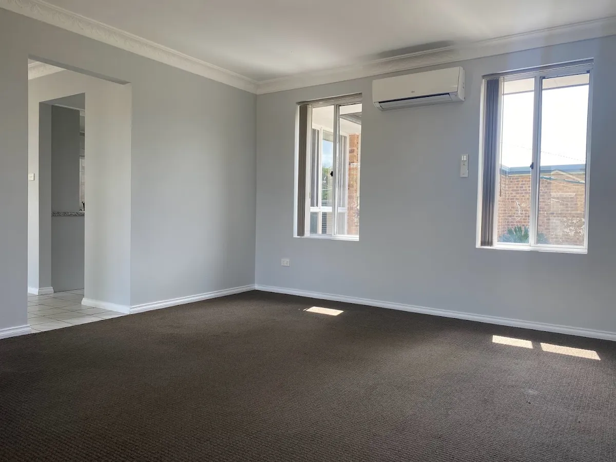 Carpeted living area with air conditioner