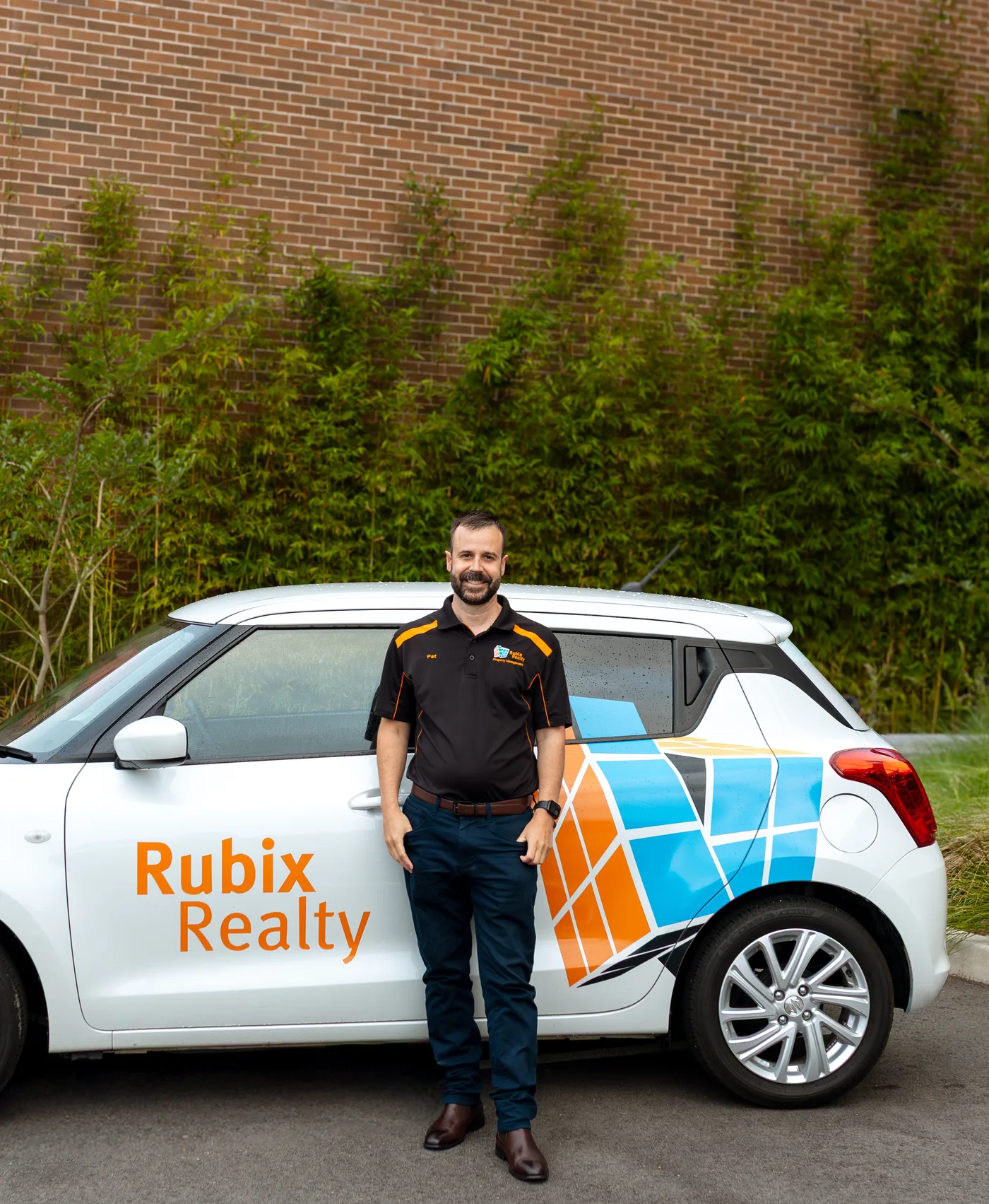 Patrick Mears standing with the Rubix Realty car in Maitland