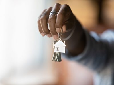 Welcome to new house. Close up of young african american man hand hold bunch of keys. Cropped shot of black guy real estate agent realtor give offer you client key from home flat apartment. Copy space